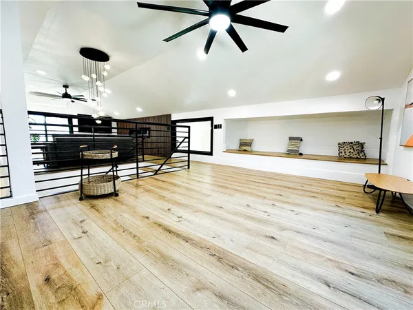 a view of an empty room with shelves and wooden floor
