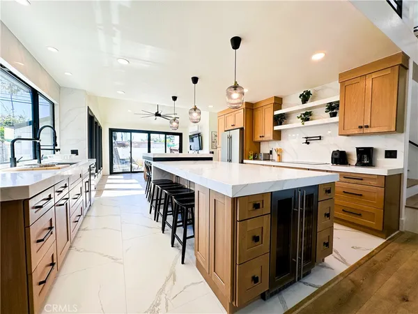 a kitchen with stainless steel appliances kitchen island a table chairs in it and wooden floors