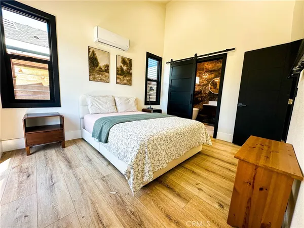 a bedroom with a bed and dresser with mirror