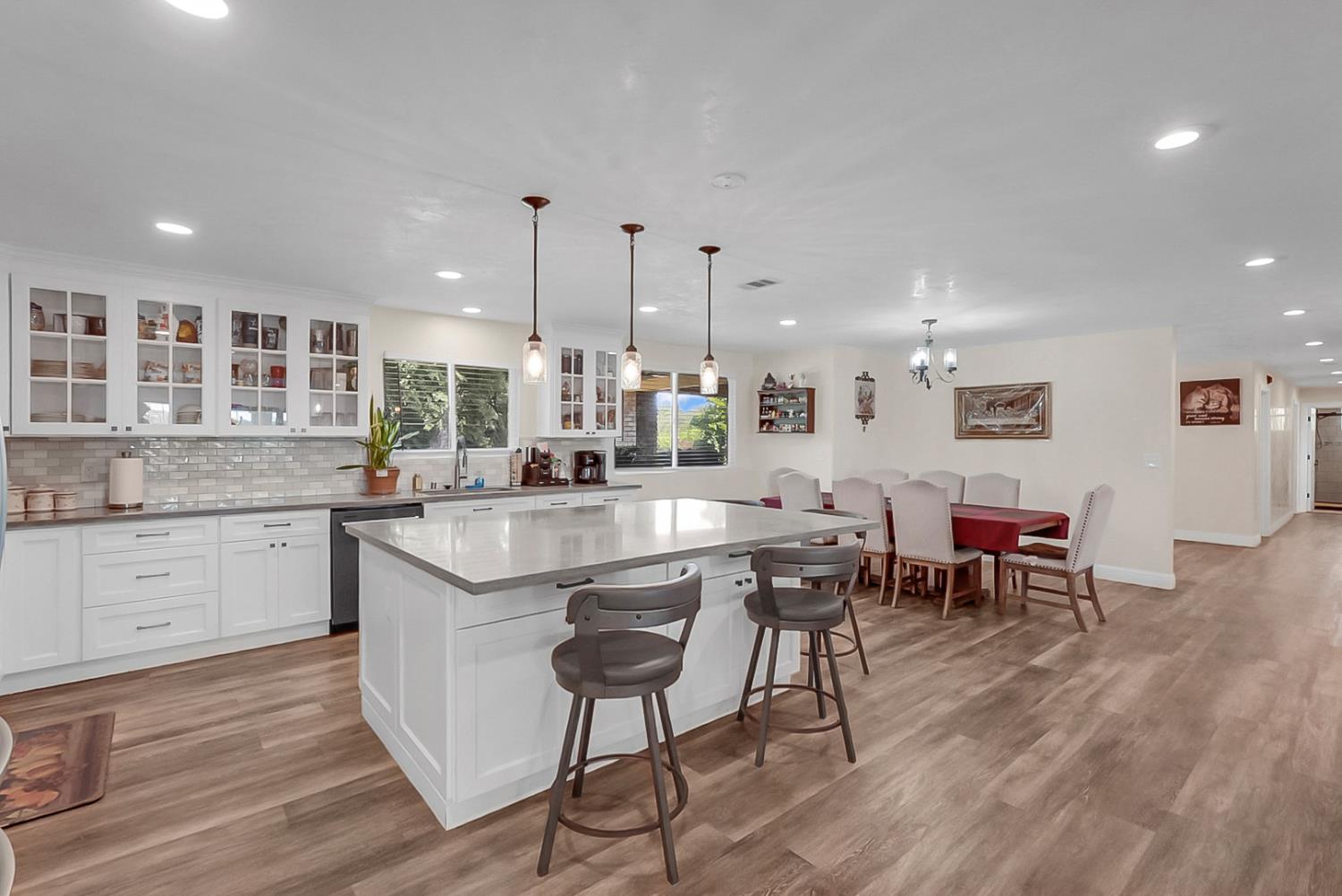 6112 Slaton Court Stockton, CA 95215 - Photo 11 of 46 a kitchen with a dining table chairs cabinets wooden floor and appliances