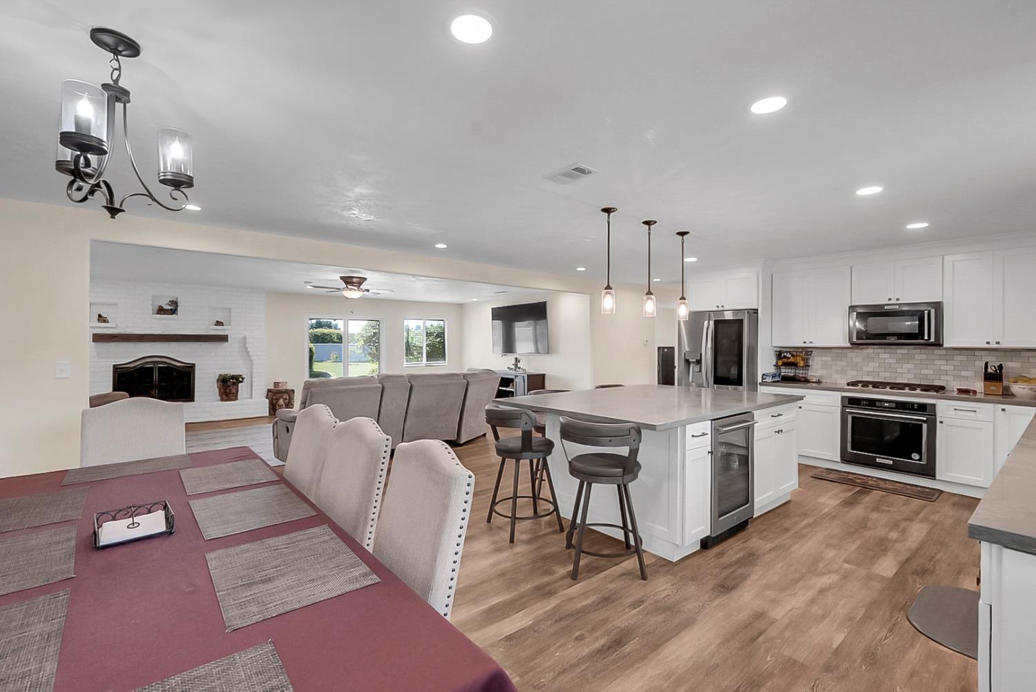 6112 Slaton Court Stockton, CA 95215 - Photo 13 of 46 a living room with stainless steel appliances kitchen island granite countertop furniture a rug kitchen view and a chandelier