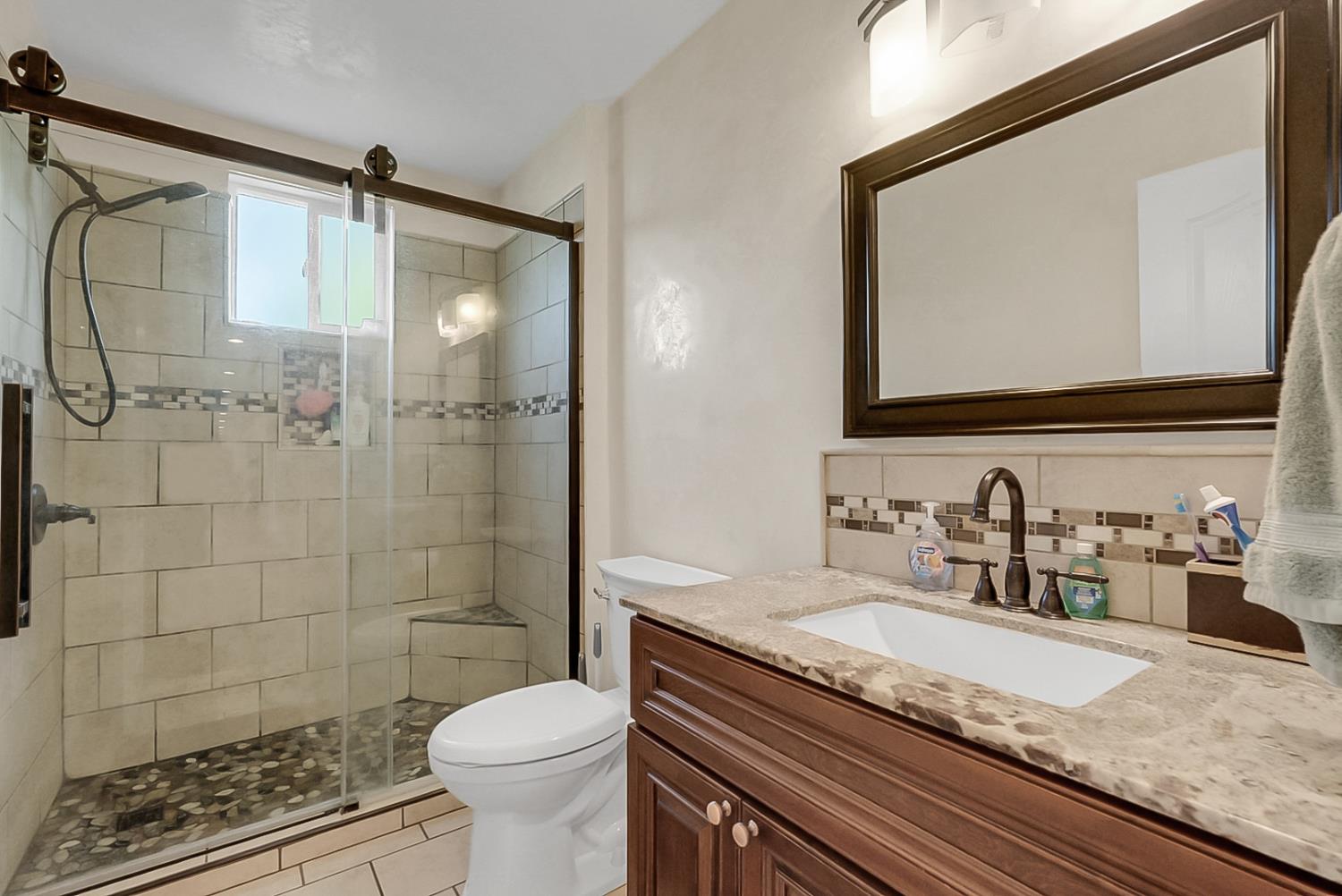 6112 Slaton Court Stockton, CA 95215 - Photo 21 of 46 a bathroom with a granite countertop sink toilet and shower