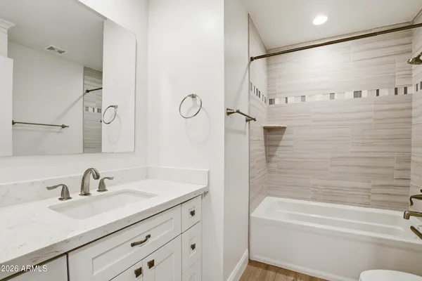 a bathroom with a granite countertop sink a toilet and shower