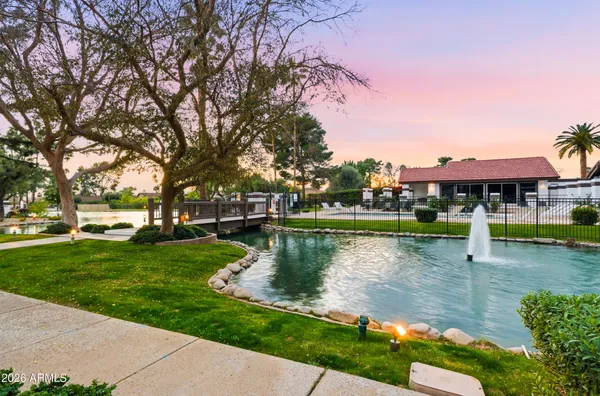 a view of a water pond with green yard