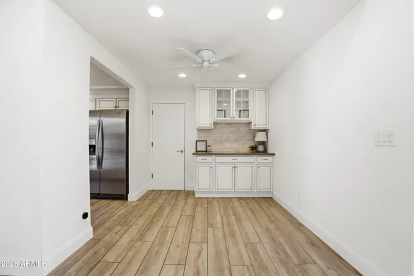 a kitchen with a refrigerator and white cabinets