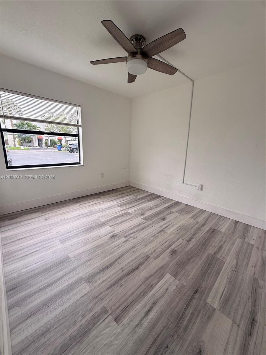 10875 Northwest 7th Street, Unit 1136 Miami, FL 33172 - Photo 12 of 25 a view of an empty room with a window and wooden floor
