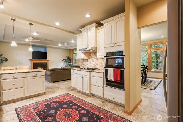 a kitchen with stainless steel appliances granite countertop a sink and a window