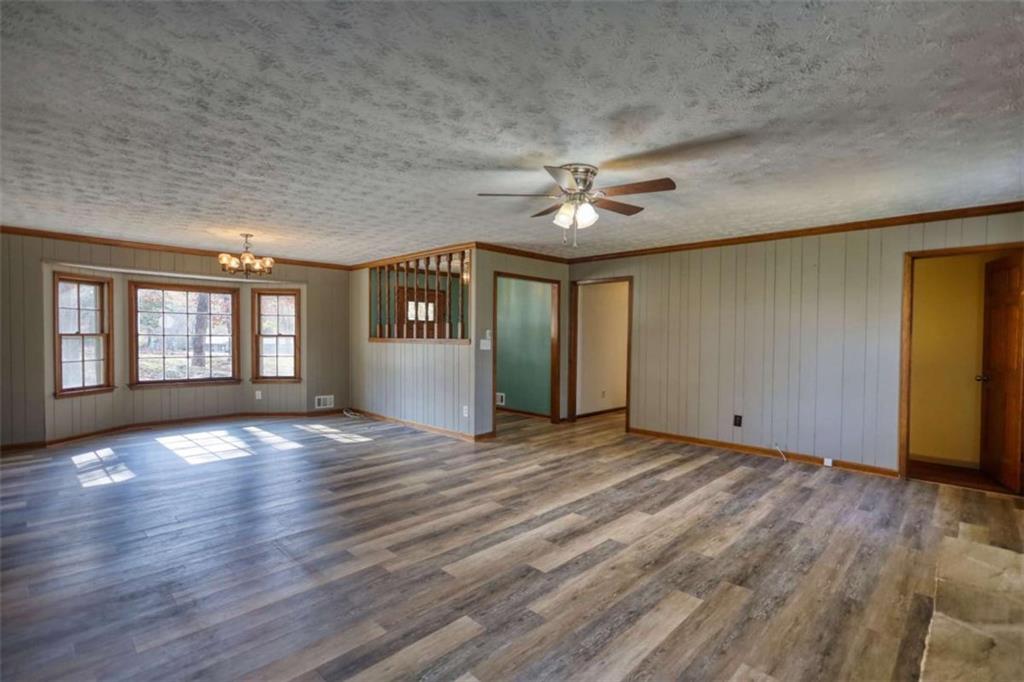 2289 Amberbrook Drive Southwest Conyers, GA 30094 - Photo 13 of 79 an empty room with wooden floor chandelier and glass door