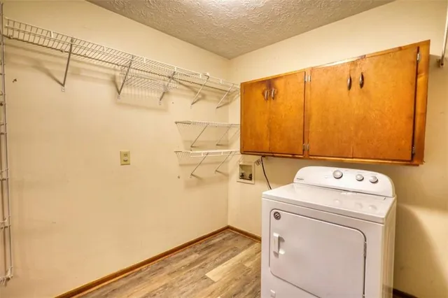 a bedroom with a bed a window and potted plant on the dresser