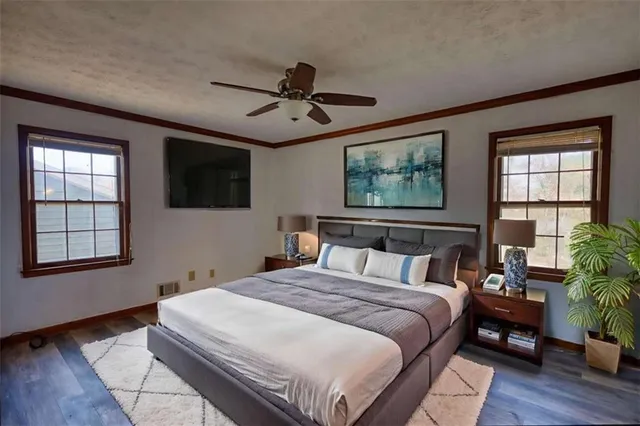 an empty room with windows and chandelier fan