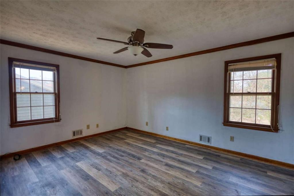 2289 Amberbrook Drive Southwest Conyers, GA 30094 - Photo 27 of 79 an empty room with wooden floor fan and windows