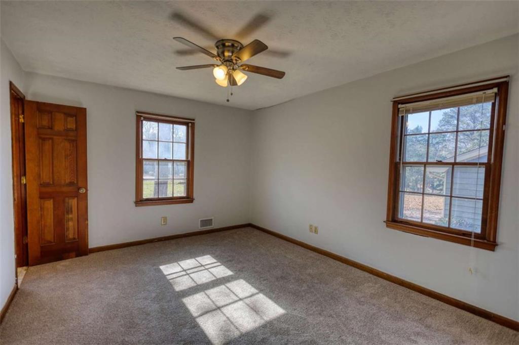 2289 Amberbrook Drive Southwest Conyers, GA 30094 - Photo 40 of 79 an empty room with windows and chandelier fan