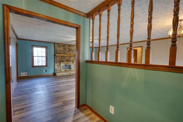 a view of a living room with wooden floor and a fireplace