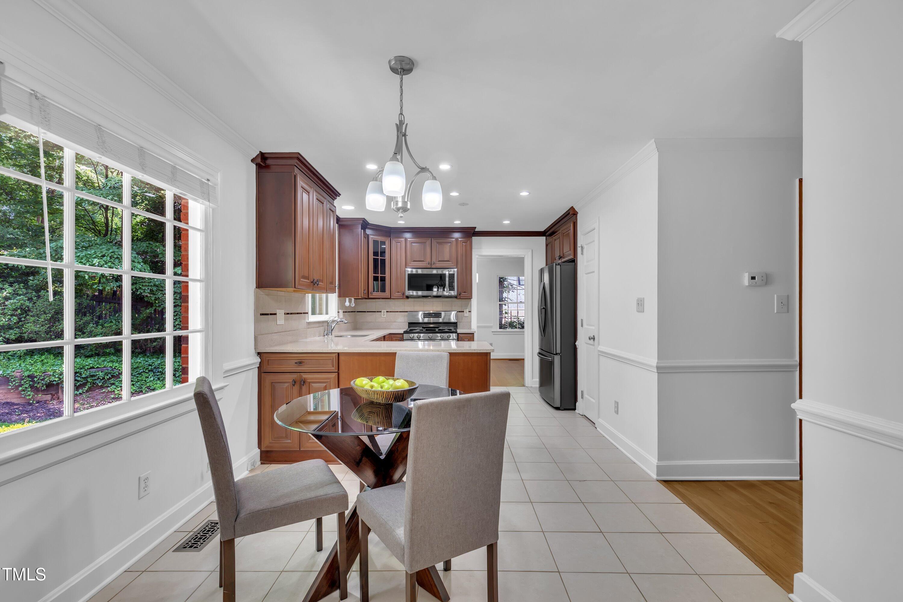 2204 Basil Drive Raleigh, NC 27612 - Photo 6 of 49 a dining room with stainless steel appliances kitchen island granite countertop a table chairs and a living room view