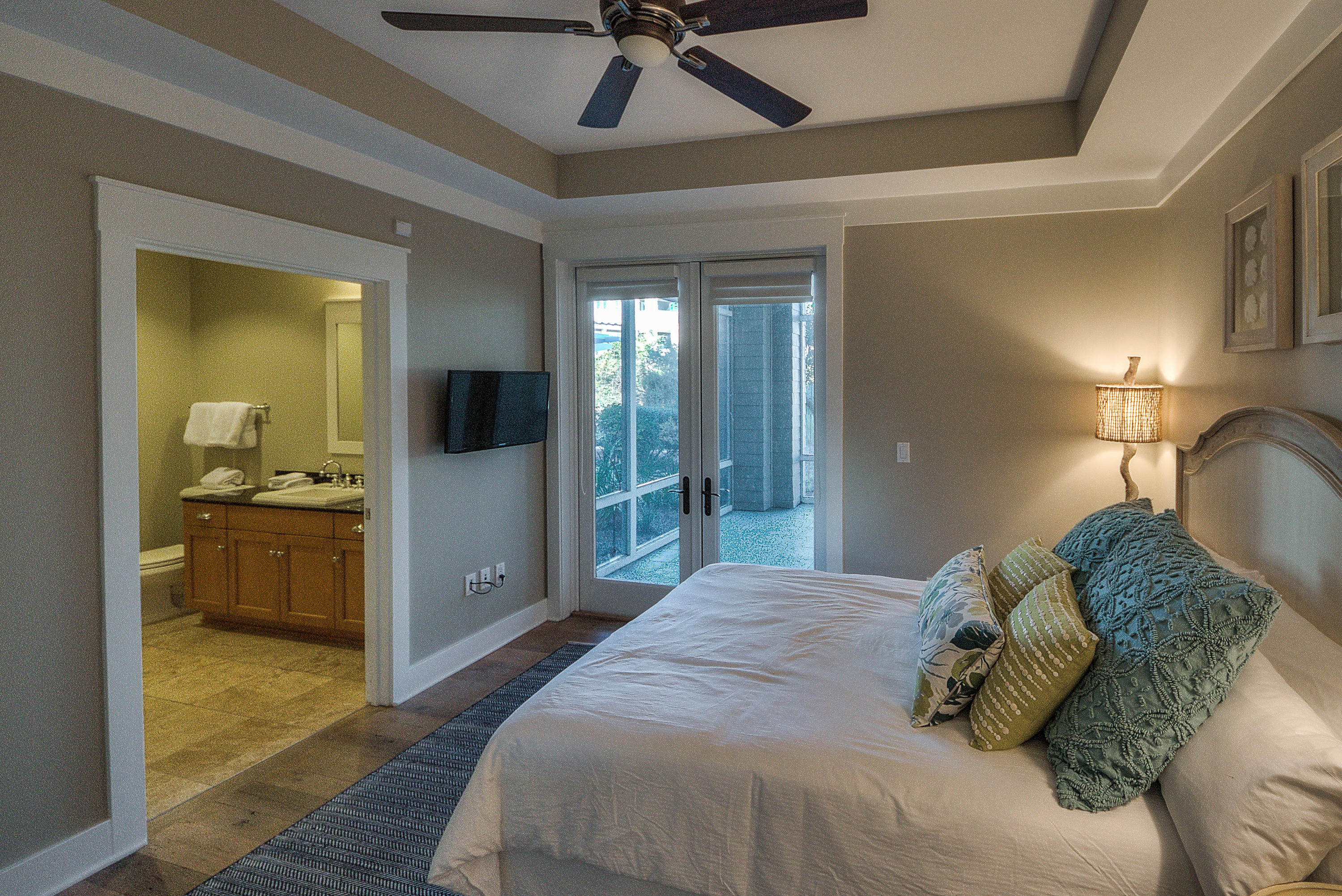 37 Compass Point Way, Unit 101 Watersound, FL 32461 - Photo 23 of 31 a spacious bedroom with a large bed and a chandelier