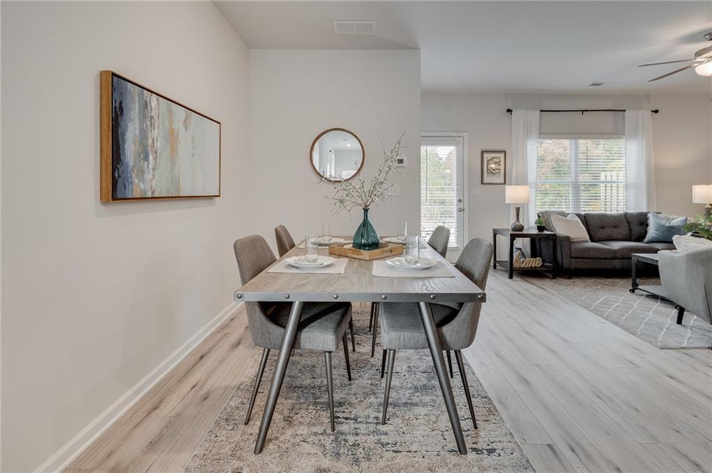 7441 Knoll Hollow Road Lithonia, GA 30058 - Photo 11 of 46 a view of a dining room with furniture and wooden floor