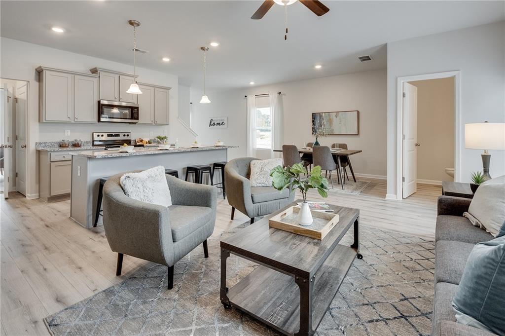 7441 Knoll Hollow Road Lithonia, GA 30058 - Photo 17 of 46 a living room with stainless steel appliances kitchen island granite countertop furniture a rug kitchen view and a refrigerator