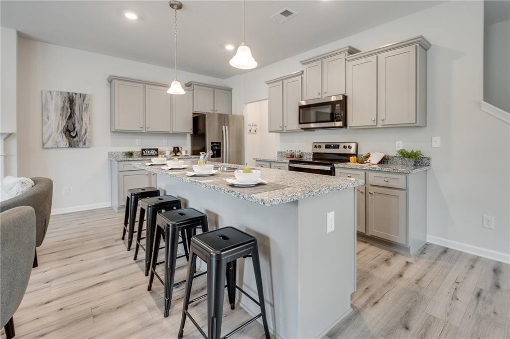7441 Knoll Hollow Road Lithonia, GA 30058 - Photo 19 of 46 a kitchen with a table chairs refrigerator and microwave