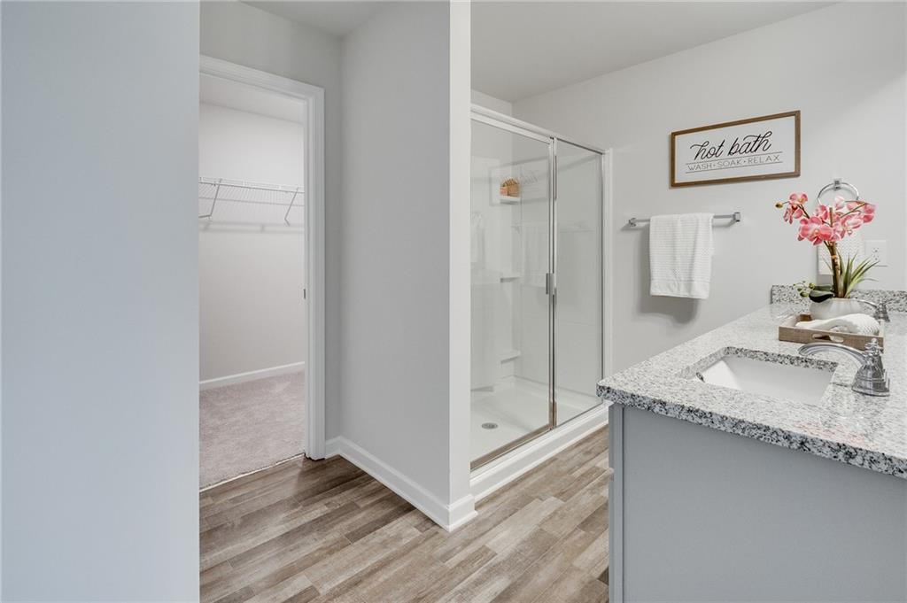 7441 Knoll Hollow Road Lithonia, GA 30058 - Photo 29 of 46 a bathroom with a granite countertop sink a mirror and a shower
