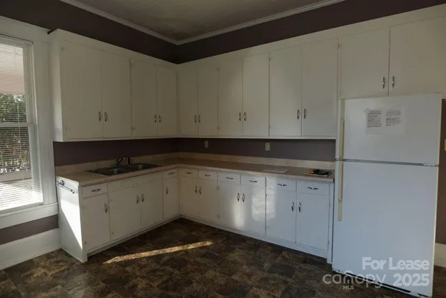a kitchen with granite countertop white cabinets and a stove