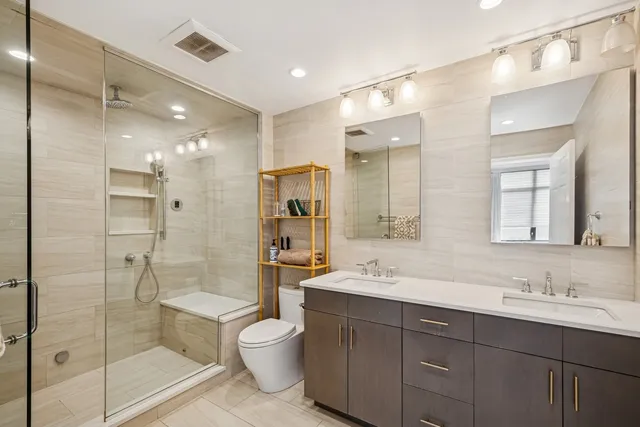 a bathroom with a shower sink double vanity and mirror