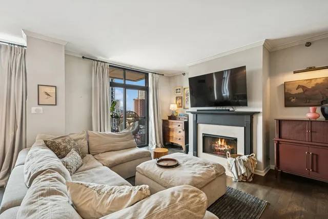 a living room with furniture a flat screen tv and a fireplace
