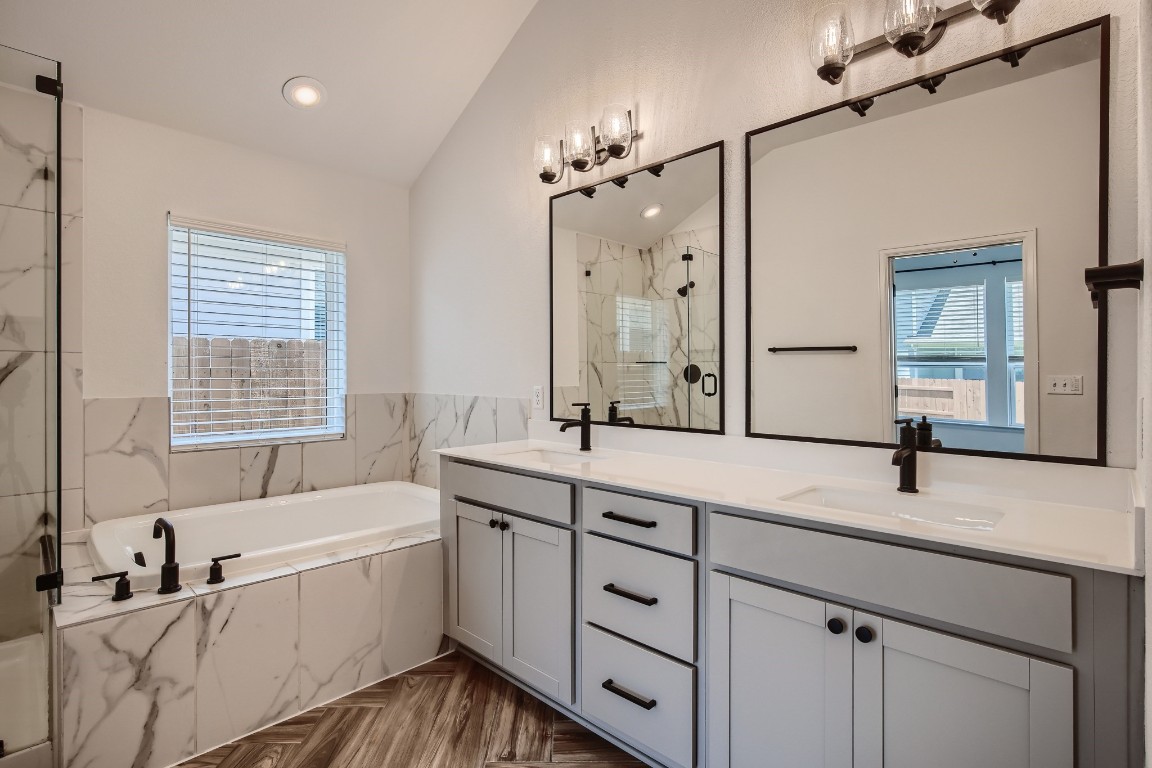 7904 Gilwice Lane Austin, TX 78744 - Photo 14 of 24 a bathroom with a two sinks a large mirror and a bathtub next to a window