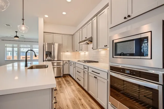 a kitchen with stainless steel appliances a stove sink microwave and cabinets