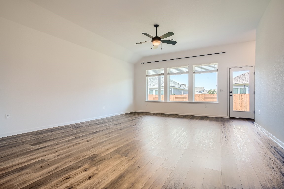 7904 Gilwice Lane Austin, TX 78744 - Photo 6 of 24 a view of an empty room with wooden floor and a window