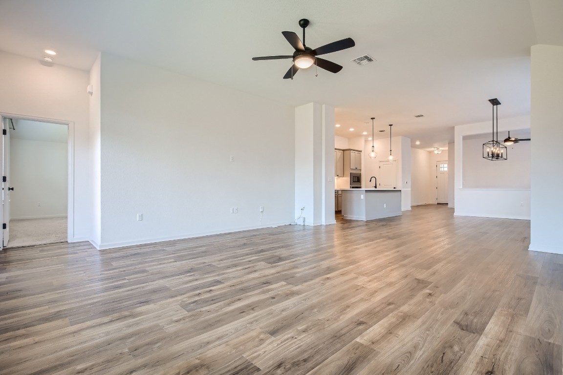 7904 Gilwice Lane Austin, TX 78744 - Photo 7 of 24 a view of a big room with wooden floor and a kitchen view