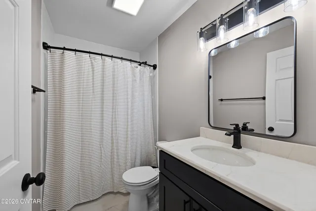 a bathroom with a sink a toilet and a mirror