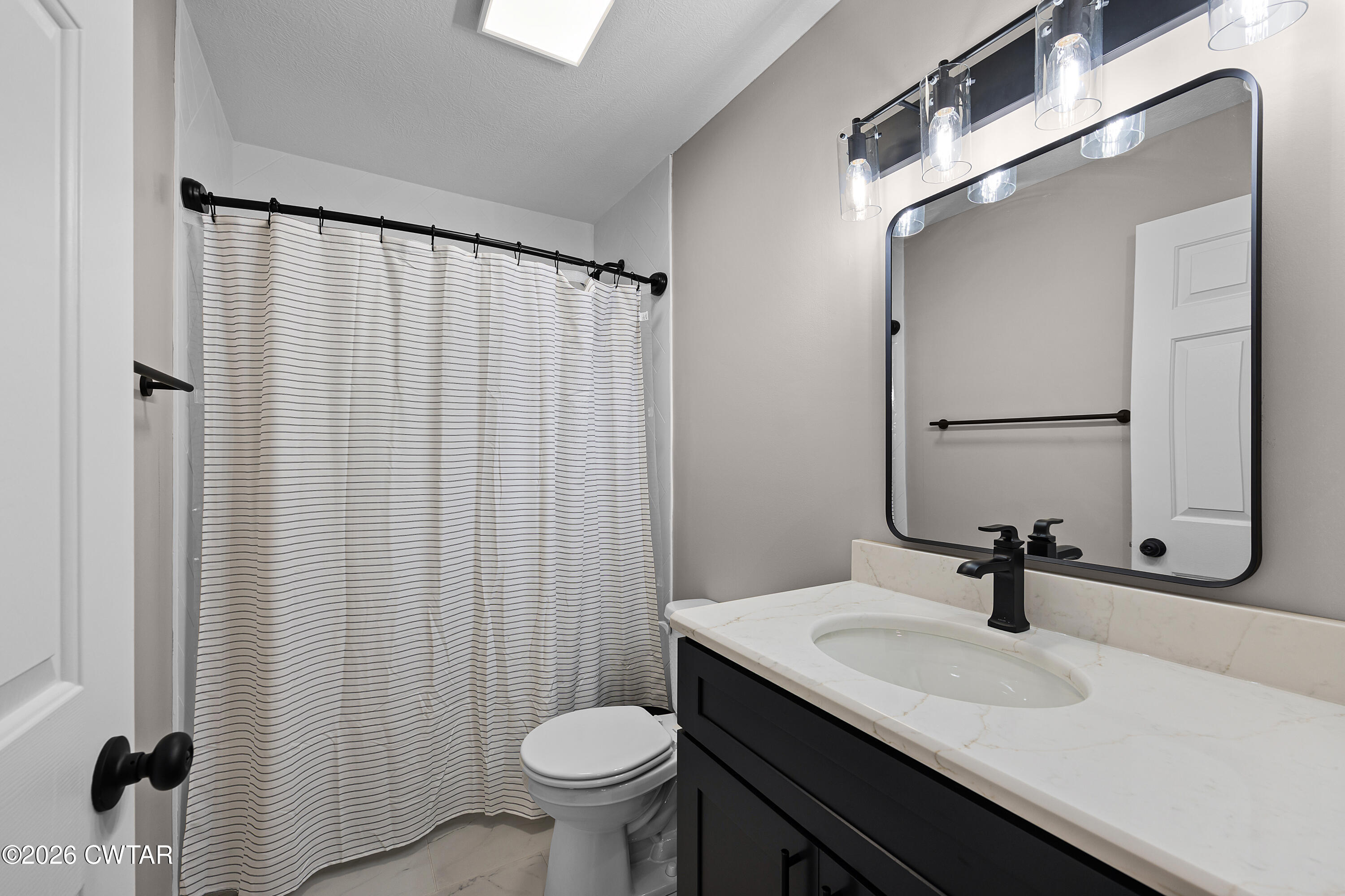 2436 Beech Bluff Road Jackson, TN 38301 - Photo 13 of 18 a bathroom with a sink a toilet and a mirror