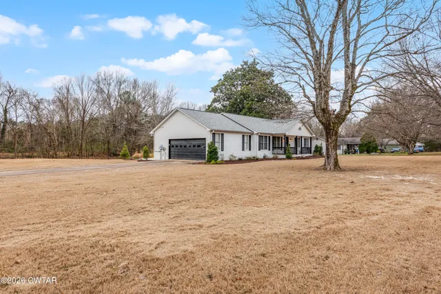 a front view of house with yard and trees
