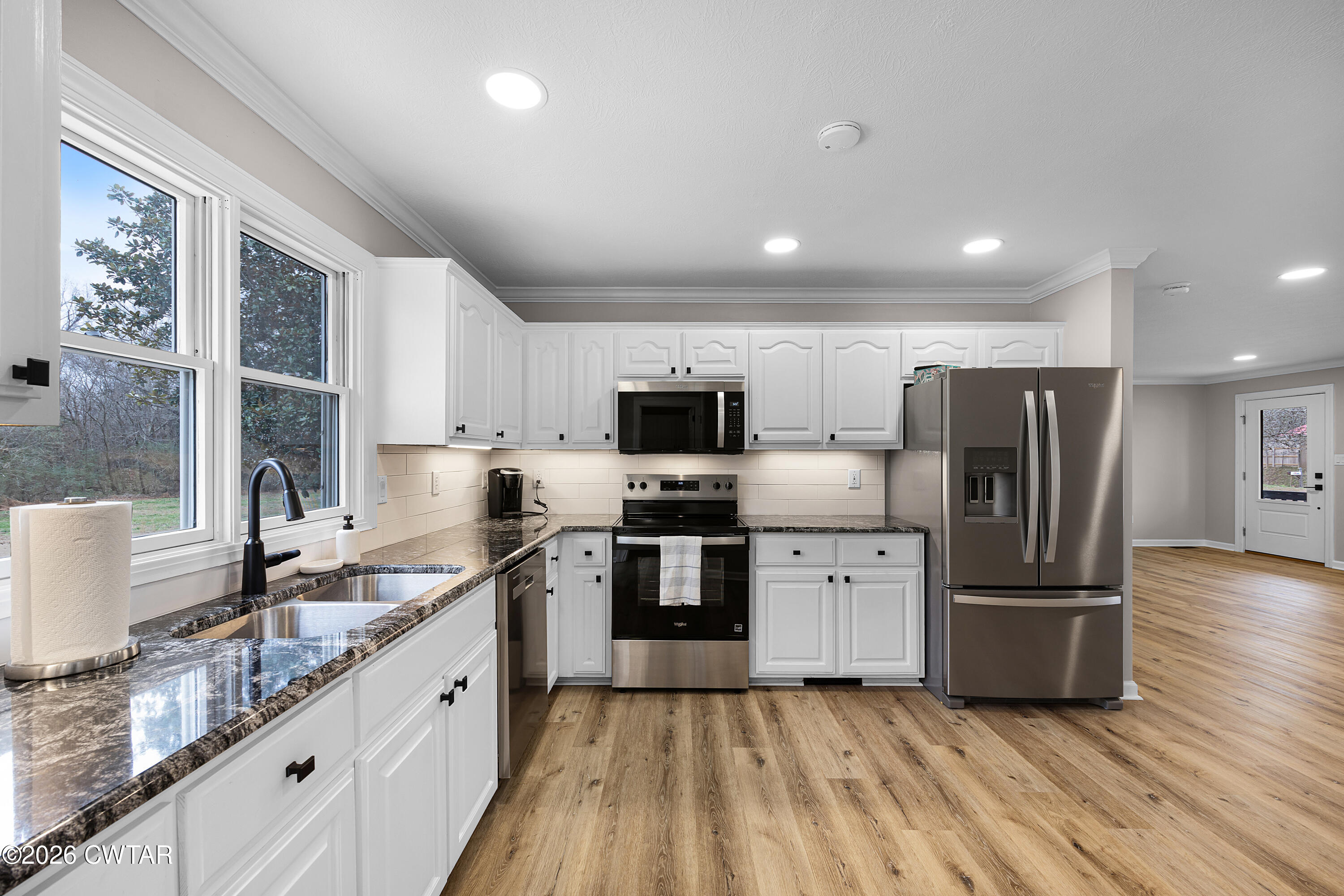 2436 Beech Bluff Road Jackson, TN 38301 - Photo 6 of 18 a kitchen with stainless steel appliances granite countertop a refrigerator a sink a stove a microwave and wooden cabinets