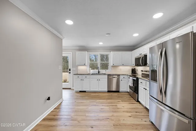 a kitchen with stainless steel appliances a refrigerator sink and cabinets