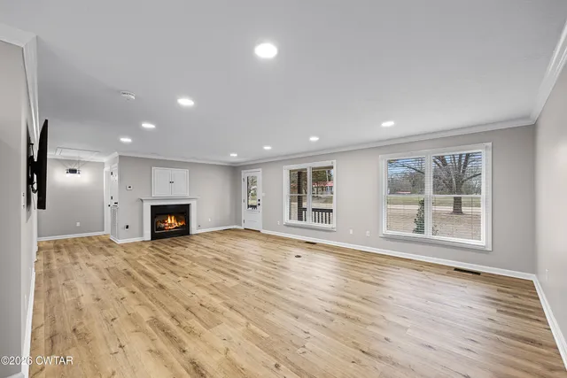an empty room with wooden floor and fireplace