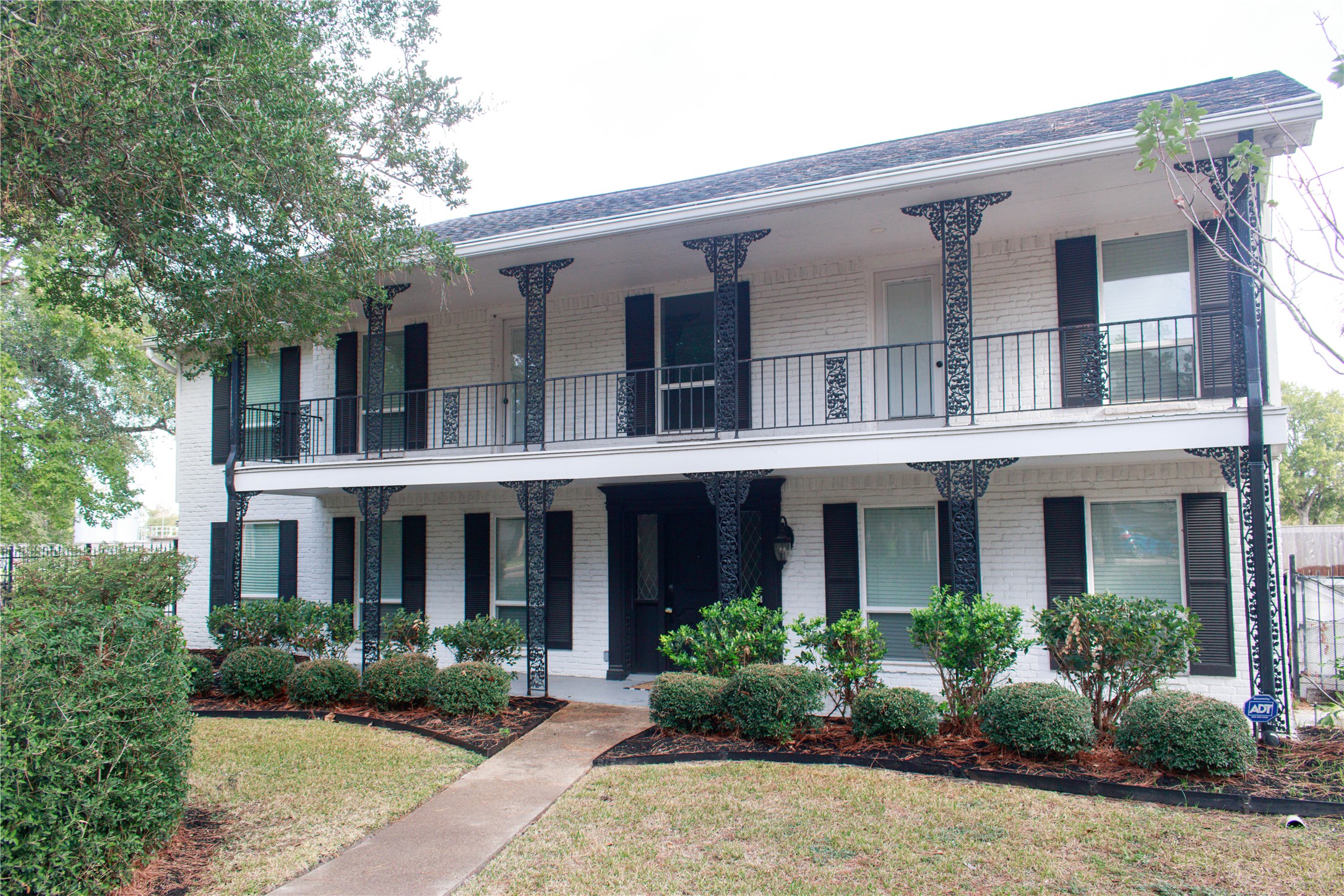 front view of a brick house with a yard