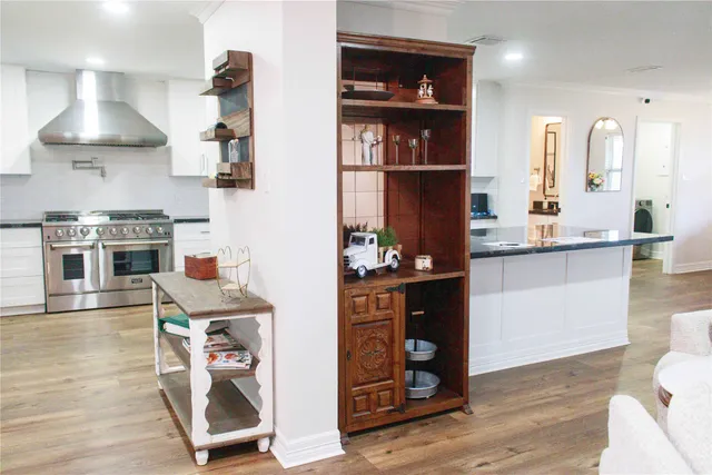 a kitchen with stainless steel appliances a stove a refrigerator and wooden floor