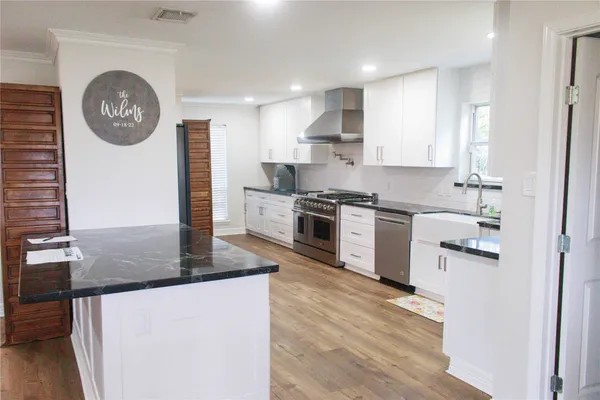 a kitchen with stainless steel appliances granite countertop a stove and a refrigerator