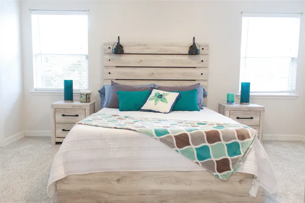 a bedroom with a large bed and a chandelier