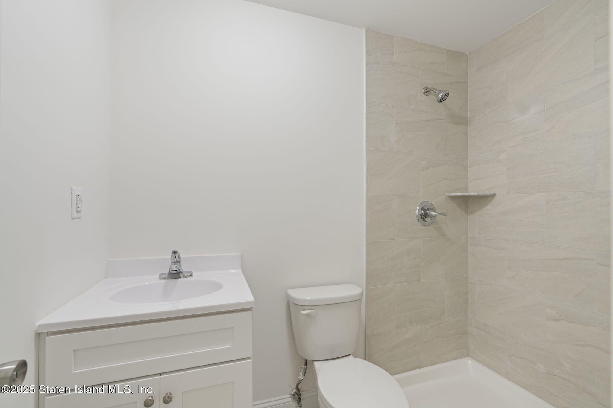 1370 Forest Hill Road, Unit 2B Staten Island, NY 10314 - Photo 16 of 20 a bathroom with a sink a toilet and shower
