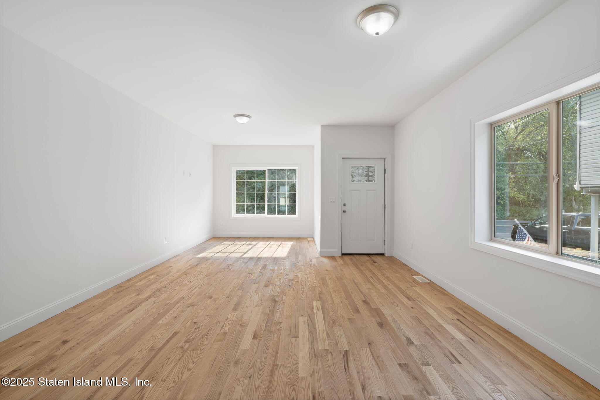 1370 Forest Hill Road, Unit 2B Staten Island, NY 10314 - Photo 2 of 20 an empty room with wooden floor and windows