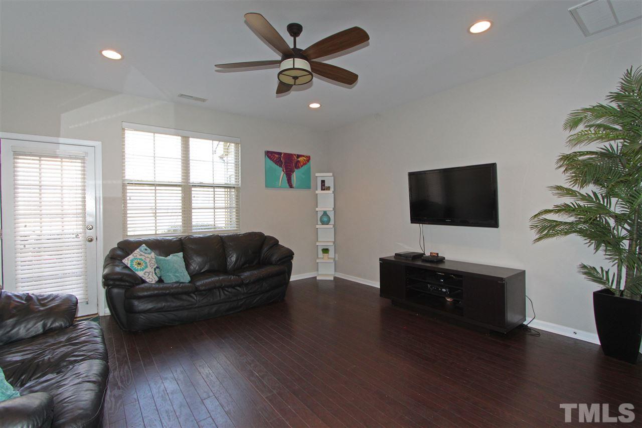 760 Wickham Ridge Road Apex, NC 27539 - Photo 12 of 25 a living room with furniture flat screen tv and wooden floor
