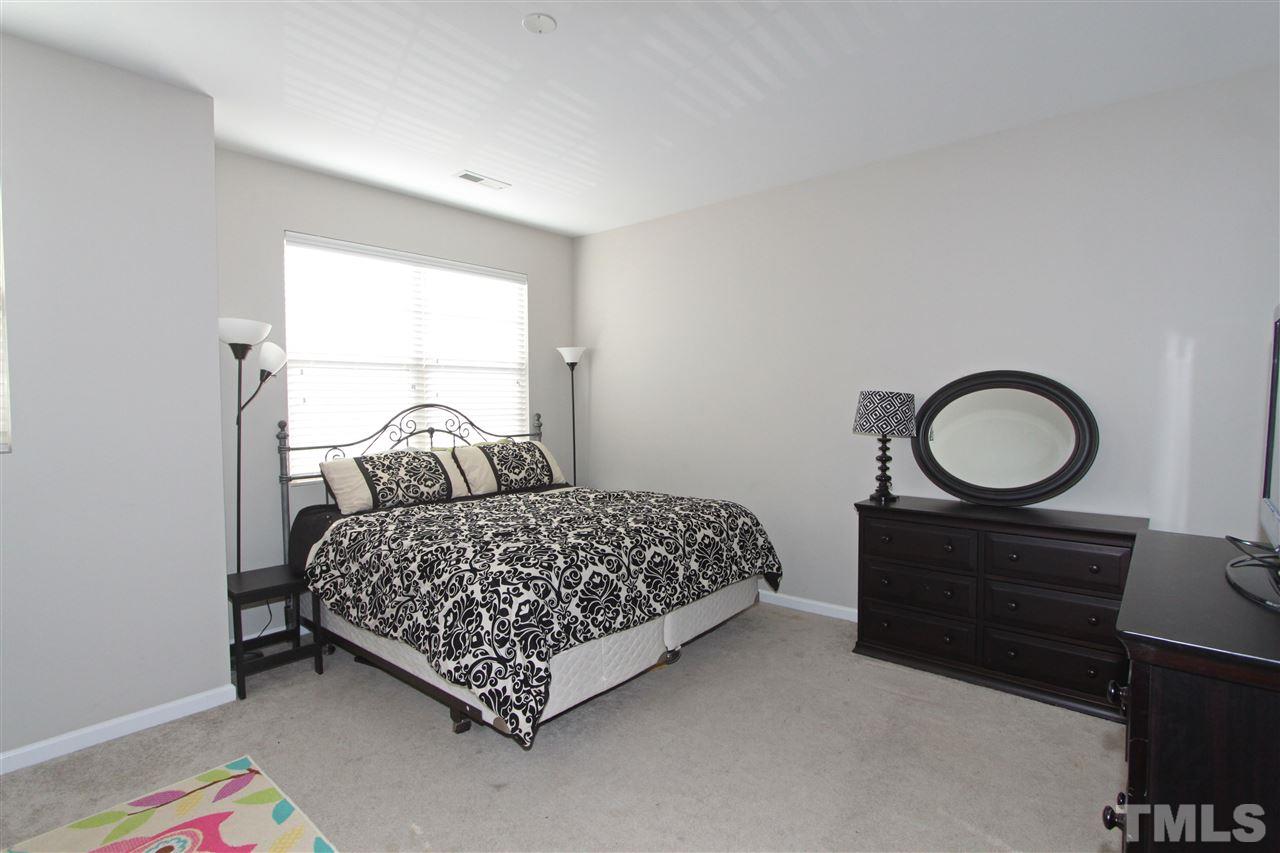760 Wickham Ridge Road Apex, NC 27539 - Photo 13 of 25 a bedroom with a bed a dresser and a window