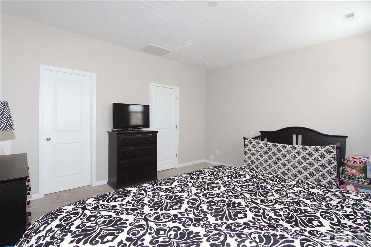 760 Wickham Ridge Road Apex, NC 27539 - Photo 15 of 25 a bedroom with a bed and a television