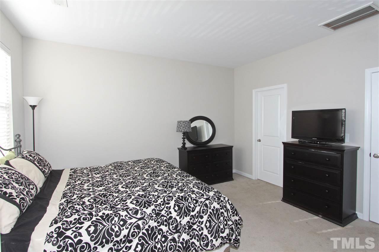 760 Wickham Ridge Road Apex, NC 27539 - Photo 16 of 25 a bedroom with a bed and a flat screen tv