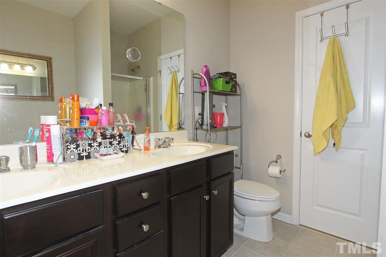 760 Wickham Ridge Road Apex, NC 27539 - Photo 17 of 25 a bathroom with a sink vanity mirror and toilet