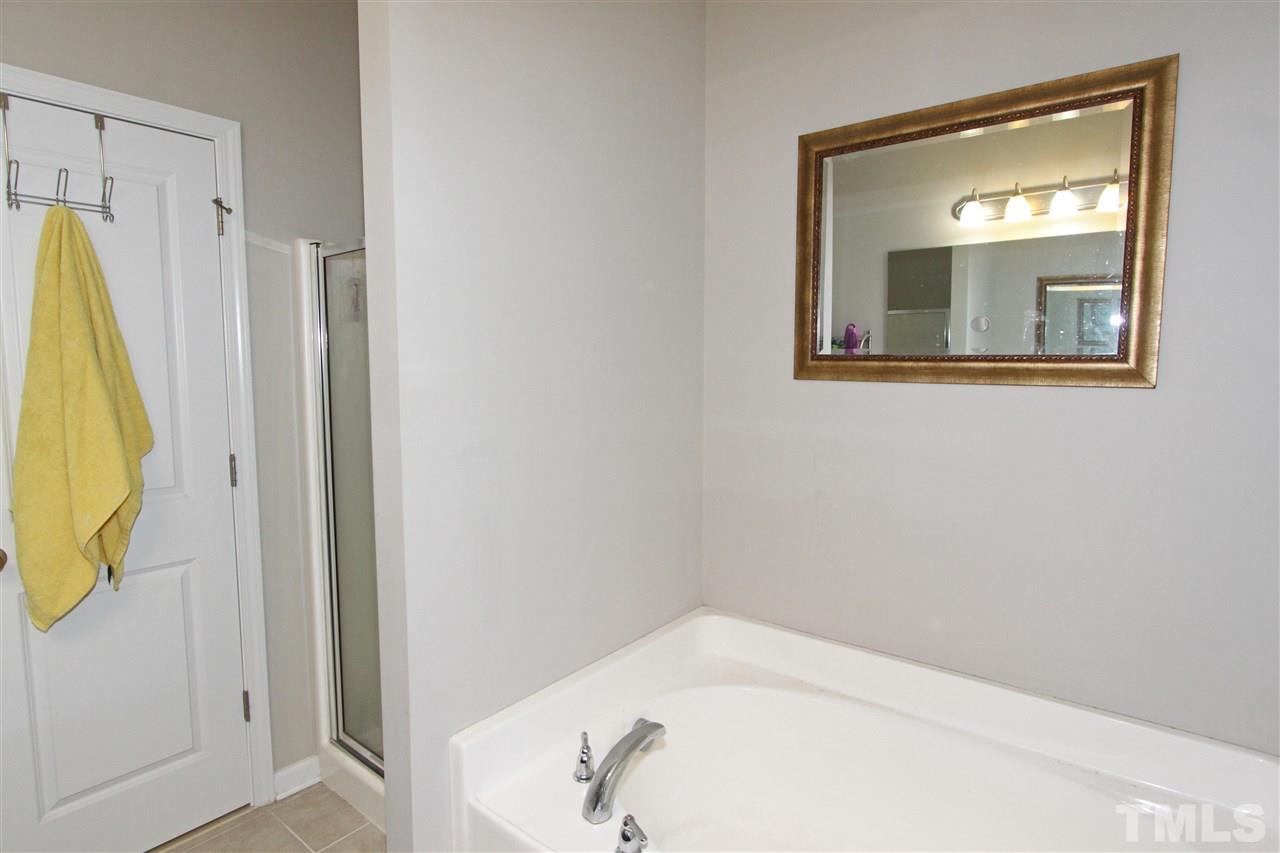 760 Wickham Ridge Road Apex, NC 27539 - Photo 18 of 25 a bathroom with a bathtub and a window