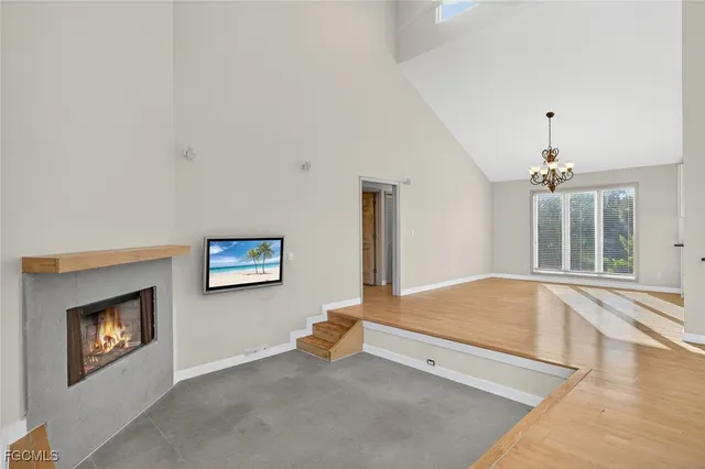 a spacious bedroom with a bed and a chandelier