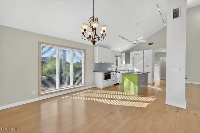 a view of a kitchen with a sink microwave and cabinets